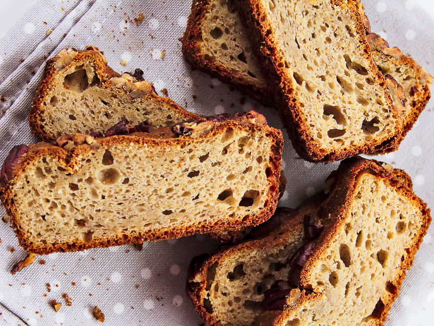 Banana bread slices, showing the inside texture, laid on a light gray white dotted towel