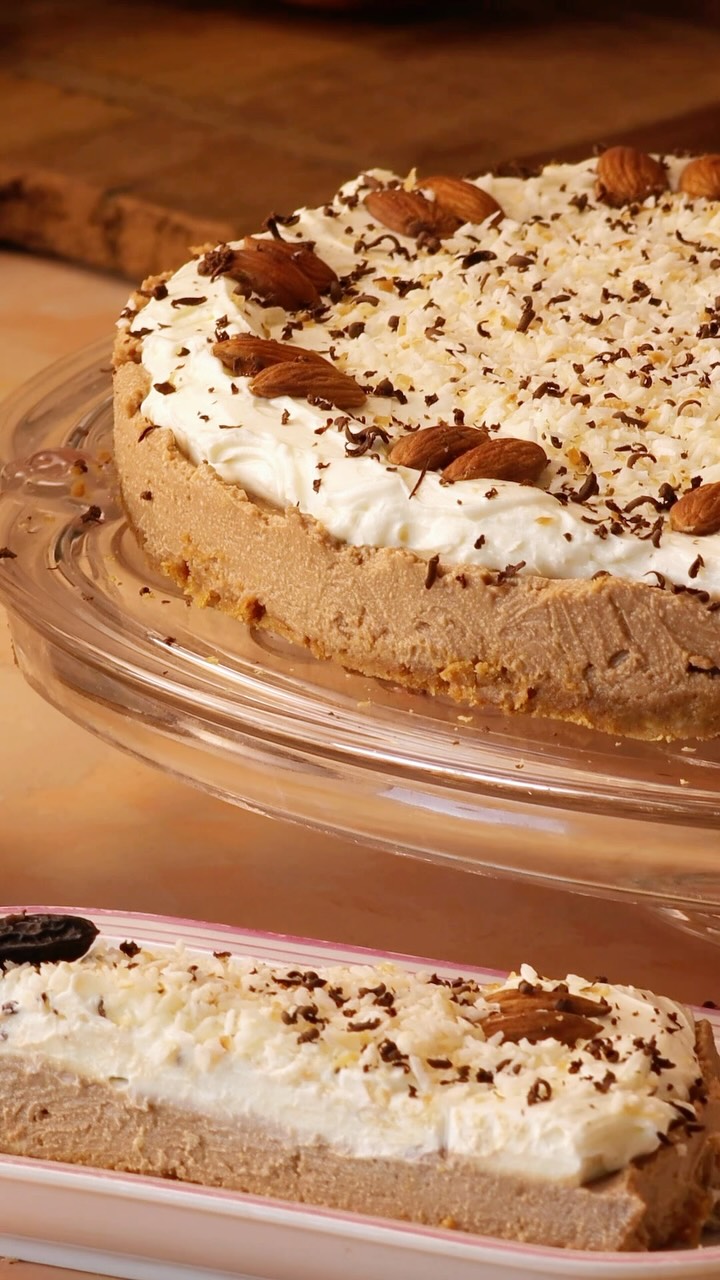 RECIPE!🍫🤎  Chocolate Coffee No-Bake Cheesecake (28 cm / 11-inch springform pan)
The coffee flavor is subtle and primarily enhances the chocolate rather than dominating the cheesecake.  ☕️Crust
* 50 g butter
* 200 g Graham crackers or Digestive biscuits
* 1,5 cups (1,2 dl) crushed almonds
* 0,5 tsp ground ginger  ☕️Filling
* 190 g milk chocolate
* 190 g white chocolate
* 200 g light cream cheese (such as Philadelphia Light or Philadelphia high-protein one)
* 400 g mascarpone
* 1 heaped teaspoon instant coffee powder
* 1/5 cup (about 0,5 dl) powdered sugar  ☕️Topping
* 200 g cream cheese (can be full-fat this time)
* 200 Greek yogurt
* Desiccated lightly roasted coconut, roasted whole almonds, shaved and whole Tonka beans (optional), shaved dark chocolate.
Instructions
1. Melt the butter. Crush the biscuits or crackers and almonds in the food processor, then mix them with the melted butter.
2. Line the bottom of a springform pan with parchment paper and attach the sides. Press the crumb mixture firmly onto the bottom. Chill briefly.
3. Melt both chocolates for the filling in a heatproof bowl set over simmering water (double boiler method) or in the microwave using short intervals (maximum 400 W). Stir the instant coffee powder into the warm, melted chocolate until completely dissolved. Let cool slightly.
4. Using a mixer, beat the cream cheese, mascarpone, and powdered sugar together with the chocolate mixture until smooth and silky.
5. Pour the filling over the prepared crust. Refrigerate for at least 3 hours, or until set.
6. For the topping, whisk the cream cheese and Greek yogurt together until smooth and free of lumps. Avoid overmixing or using a very high speed, as yogurt has a delicate texture.
7. Spread the topping evenly over the chilled cheesecake.
8. Decorate with slightly roasted coconut flakes, almonds, grated and whole Tonka beans (if you have them), and dark chocolate shavings. Whole Tonka beans are meant more for just a decoration, rather than eating, but in a shaved form, they give an exceptional almond flavor. You can use pecans instead of almonds, they look especially like coffee beans.
9. Keep refrigerated until ready to serve.