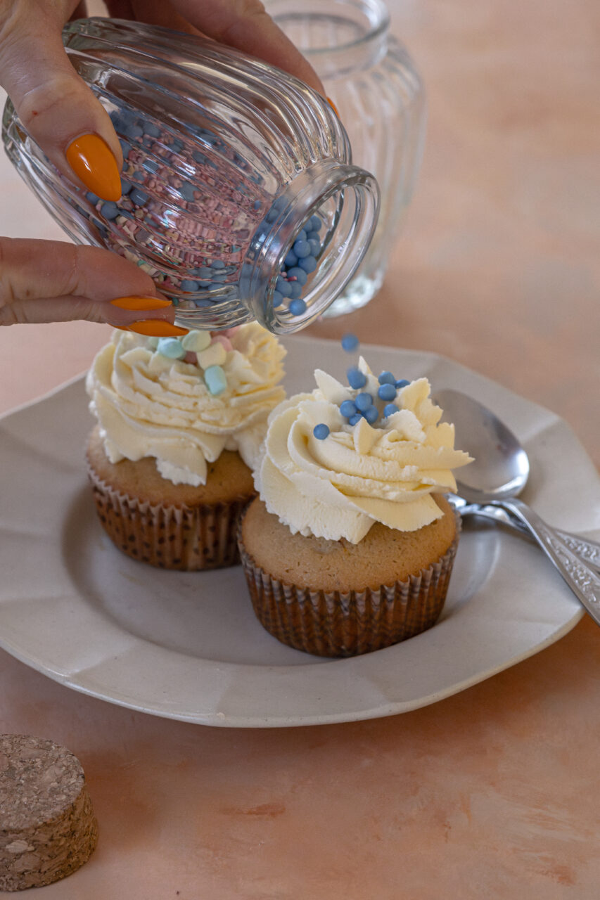 Close-up of decorating muffins with sprinkles, creating a fun and sweet topping.