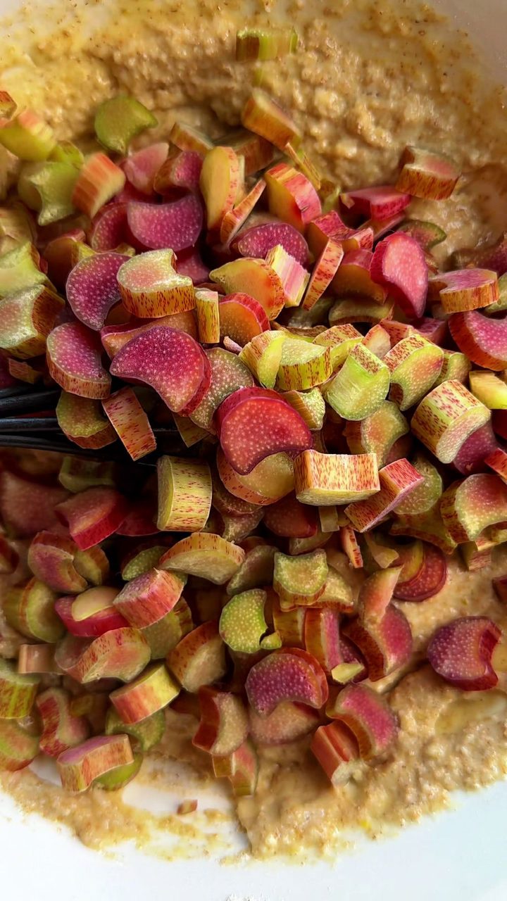Chopped rhubarb on top of the rhubarb muffin batter, ready to fold in