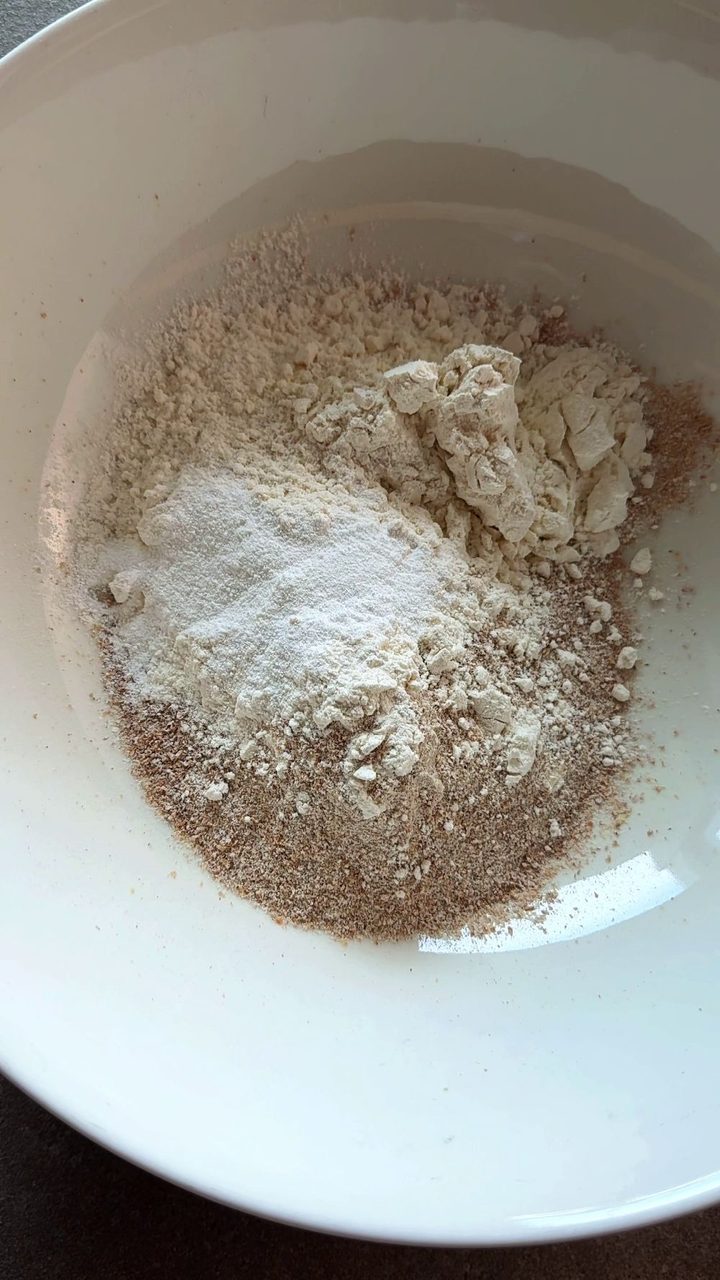 Whole wheat flour, white flour and baking powder in a white mixing bowl